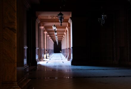 Dark uncanny corridor illustrating Jeffrey Thomas's LORE review of The Orphan Palace