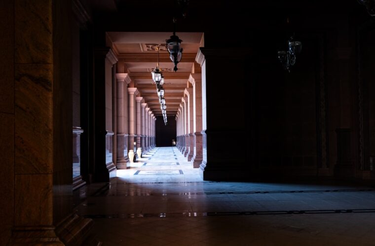 Dark uncanny corridor illustrating Jeffrey Thomas's LORE review of The Orphan Palace