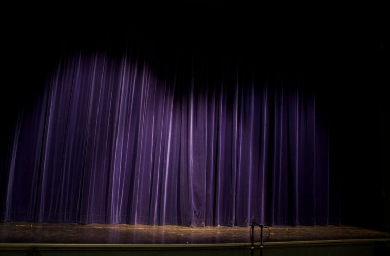 Dark theater stage and curtains evoking the dreamlike puppet imagery of Thomas Ligotti's horror fiction